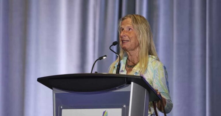 A woman behind a podium speaking.