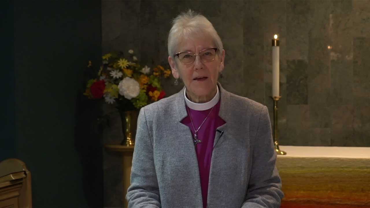 Screencapture of Archbishop Linda speaking. wearing a clerical collar and jacket.