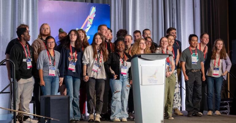 Group photo of a diverse group of young people on a stage